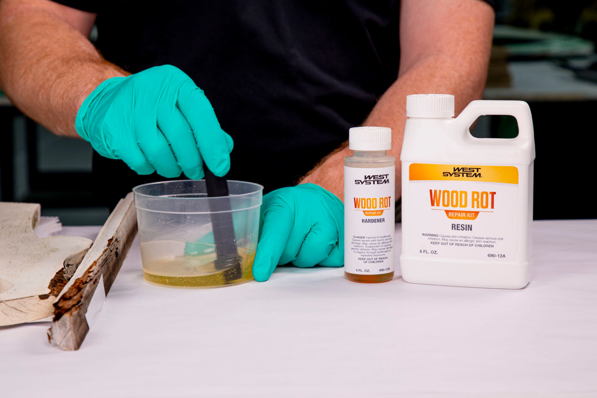 WEST SYSTEM manufacturer demonstration: mixing the 12 oz Wood Rot Repair kit beside damaged wood