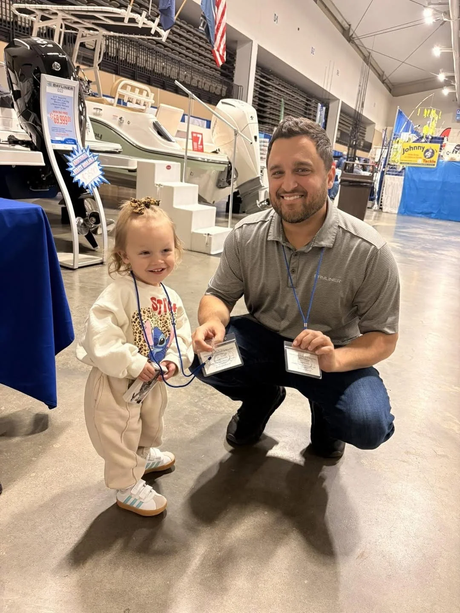 PartsDuck founder Nick Borrelli with his daughter at an indoor boat show.